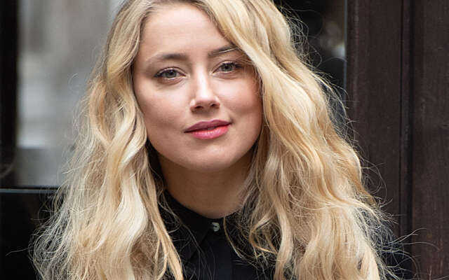 Amber Heard verschijnt met grote glimlach bij de rechtbank